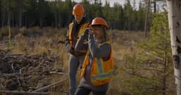 Two Firesmart workers in a forest surveyo
